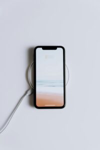 Persona utilizando smartphone mientras se carga inalámbricamente
