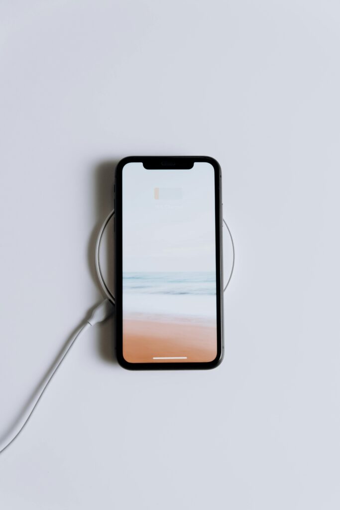 Persona utilizando smartphone mientras se carga inalámbricamente